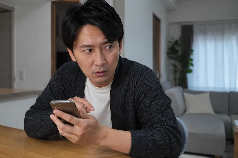 妻のスマートフォンを覗く夫